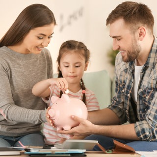 Eltern und Kind mit Sparschwein