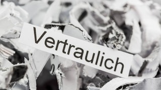 Vertrauliche und persönliche Dokumente: Papierschnipsel und ein Zettel mit dem Wort "Vertraulich"
