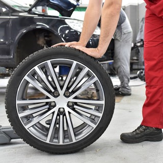 Mechaniker wechselt Reifen in einer Werkstatt