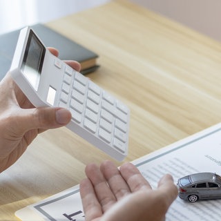 Mann mit Rechner und Unterlagen