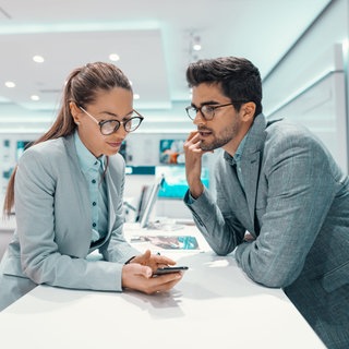 Frau berät Mann zum Handytarif