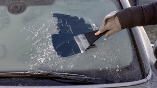 Eiskratzen an einer Frontscheibe | Autoscheibe von Eis befreien – ohne Eiskratzer