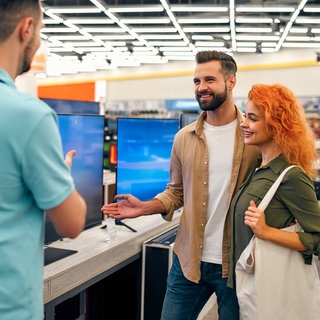 Paar lässt sich beim Fernsehkauf beraten