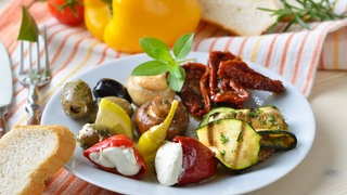 verschiedene Antipasti mit Brot auf dem Teller