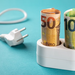 Geld steckt in Mehrfachsteckdose