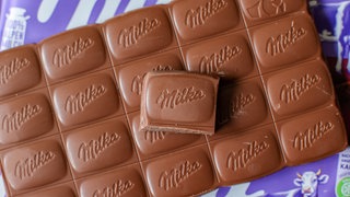 Eine Tafel Milka Alpenmilch-Schokolade liegt auf dem Tisch. Mondelez hat die Packungsgröße von 100 Gramm auf 90 Gramm geschrumpft, den Preis aber von 1,49 Euro auf 1,99 Euro erhöht. Verbraucher wählen die Tafel deshalb zur Mogelpackung des Jahres 2025. 