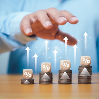 Würfel, Münzen, Pfeile nach oben, ein Mann hält die Hand darüber