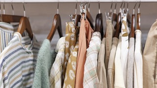Symbolbild: Kleidungsstücke hängen an Kleiderbügeln | Schadstoffe in neuer Kleidung: Das solltet ihr beim Kauf beachten