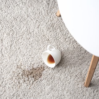 Kaffeetasse liegt ausgeleert auf dem Teppich