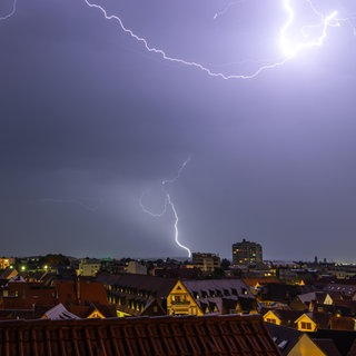 Gewitter mit Blitzen über Häuserdächern | Bei Gewitter und Blitzen: So schützt ihr eure elektronischen Geräte