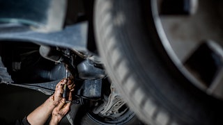 Ein Mann repariert ein Auto mit Ersatzteilen.