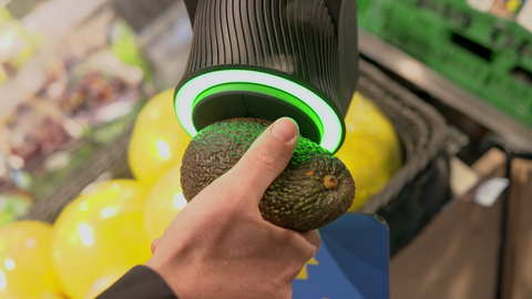 Avocado wird an einen Scanner gehalten, der grün leuchtet