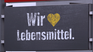 Edeka Schild mit "Wir lieben Lebensmittel". Wie gut ist Edeka – warum gibt es große Unterschiede von Markt zu Markt? Preise, Qualität, Service: Wir nehmen Deutschlands größte Supermarktkette unter die Lupe.