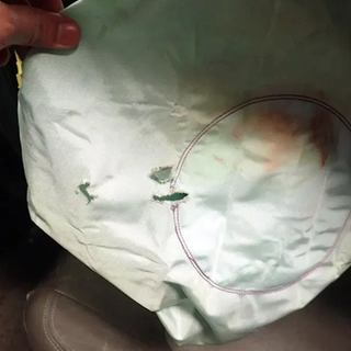 Takata-Airbag mit Löchern und rötlichen Spuren. Die gefährlichen Airbags wurden in Millionen Fahrzeugen verbaut.