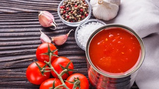 Tomaten aus der Dose auf Holzhintergrund