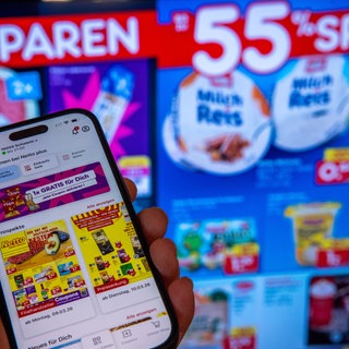 Ein Smartphone mit der Rabatt-App des Discounters Netto ist vor Werbeanzeigen zu sehen. Der Bundesverband der Verbraucherzentralen klagt gegen Netto - die App verstoße gegen den Gleichheitsgrundsatz und benachteilige Kunden, die die App nicht nutzen könnten oder wollten.