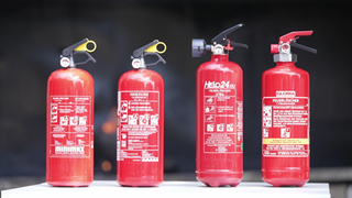 Zu sehen sind vier Feuerlöscher. Zwei Pulverlöscher: Das Markenprodukt von Minimax für rund 64 Euro und ein günstiges No-Name-Produkt, gekauft bei Amazon für 26,99 Euro. Zudem zwei Schaumlöscher: Ein Markenprodukt von Gloria für 78,99 Euro, dazu ein Schaumlöscher von Helo24 für 34 Euro.