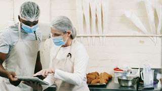 Lebensmittelkontrolle, zwei Personen in einer Küche: Metall im Gebäck, Keime in Wurst, Viren auf Beeren - in Deutschland werden hunderte Produkte zurückgerufen. Wer informiert, wie schnell – und wie können sich Verbraucher schützen?