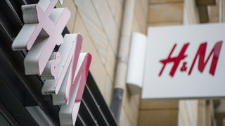 Zu sehen sind ein Logo und ein Schaufenster von H&M.