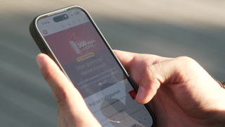 Zu sehen sind Hände, die ein Handy halten. Auf dem Bildschirm ist ein Werbeangebot von Vodafone zu sehen.  