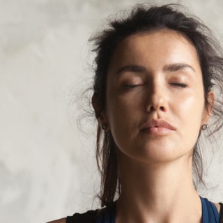 Frau macht Gesichtsyoga