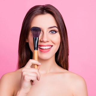 Frau mit Schinkpinsel und geschminkten Augen