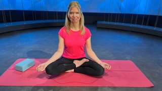 Yoga-Übung am Abend - halber Lotussitz