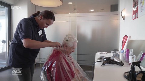 Friseurin schneidet einer Frau die Haare