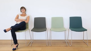 Frau wartet in einem Wartezimmer | Was hilft bei nervigem Warten?