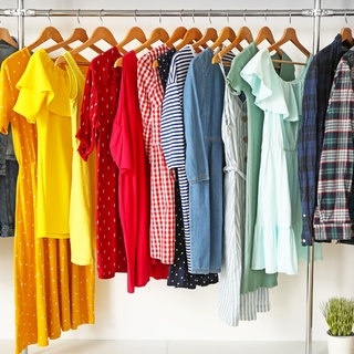 Kleidung in verschiedenen Farben hängen auf der Kleiderstange