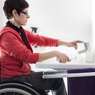 Frau mit Rollstuhl beim Zähneputzen