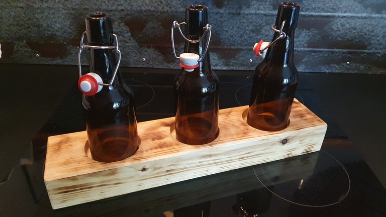 Bügelverschlüsse wieder an den Flaschen anbringen. 