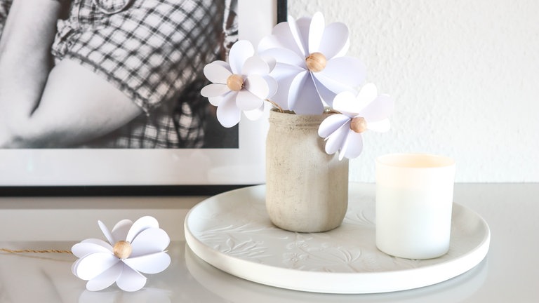 Die fertigen Papierblumen in eine Vase oder ein bemaltes Glas stellen.