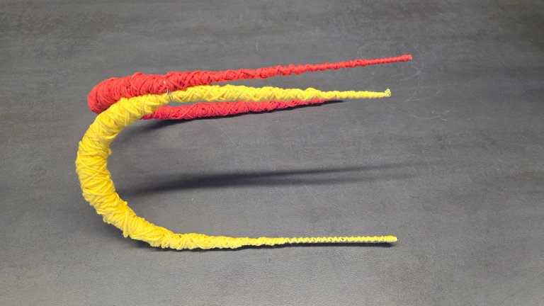 Die Bögen werden mit Draht an den schmalen Enden miteinander fixiert. Dadurch bleiben die Bögen von alleine stehen. 