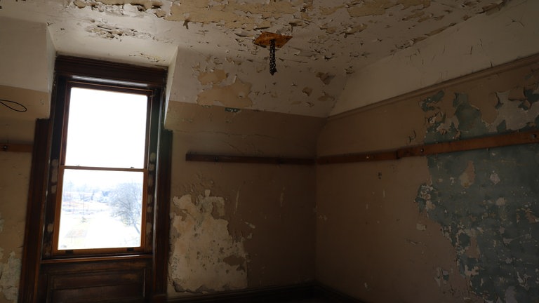 Ein Raum mit kaputten Wandtapeten