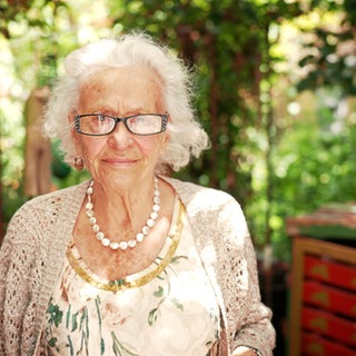 Elisabeth Gateff steht im Garten und sieht in die Kamera