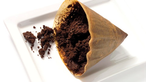 Filtertüte mit Kaffeesatz, den man im Garten verwenden kann