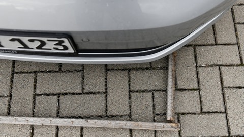 Drahtgitter unter einem Auto: Um einen Marder zu vertreiben, kann ein Drahtgitter in einem Holzrahmen helfen: Unter das Auto geschoben unterstützt dieses bei der Abwehr der Tiere.