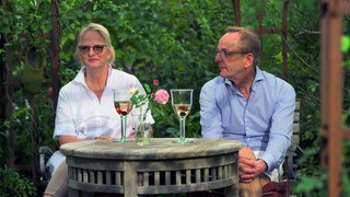 Petra und Ralf Wichert sitzen an einem Tisch in ihrem Garten in Sipplingen.