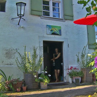 Eine Frau tritt aus der Tür des Markgräflichen Forsthauses in Salem