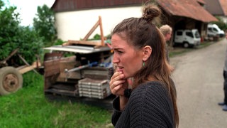 Geraldine Schüle schaut nachdenklich auf eine Baustelle auf ihrem Bauernhof