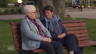 Sonja Faber-Schrecklein sitzt mit einer Frau auf einer Bank