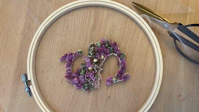 getrocknete Blüten im Stickrahmen