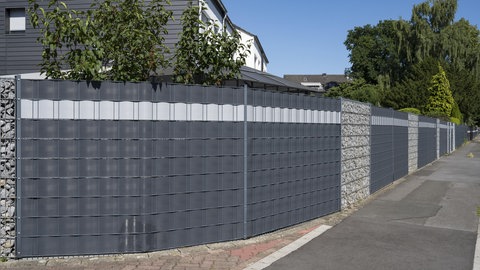 Stahlzaun statt Hecke: ein Haus hinter einem Doppelstabmattenzaun mit Sichtschutzstreifen.