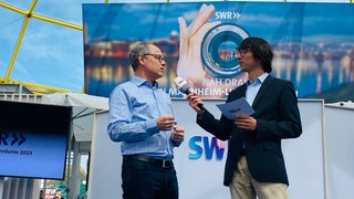 SWR-Intendant Kai Gniffke (l.) im Gläsernen Studio des SWR auf dem Maimarkt Mannheim.