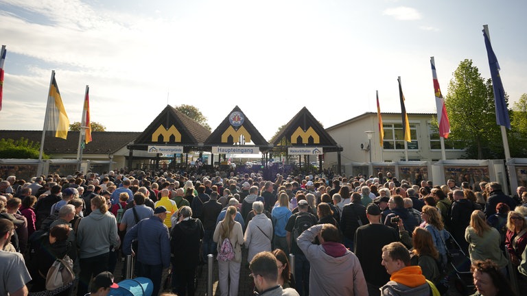 Viele Menschen stehen Schlange vor dem Eingang zum Maimarktgelände in Mannheim. Seit 9 Uhr ist das Gelände geöffnet.