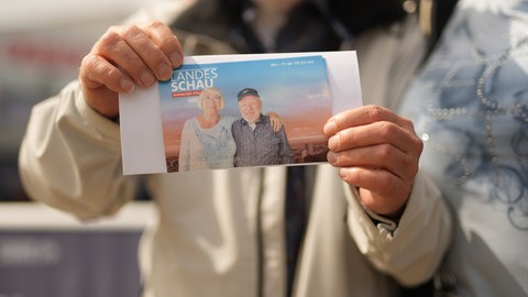 Ein Senior hält ein Foto von sich mit seiner Frau in die Kamera. Das Foto ist im SWR Automaten auf dem Mannheimer Maimarktgelände entstanden. 