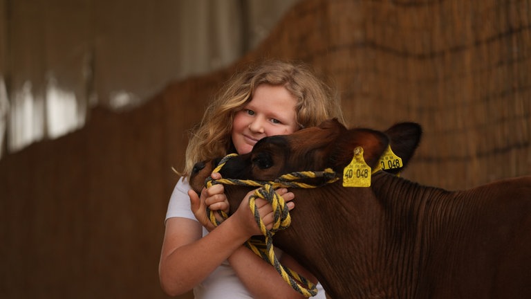 Ein Kind mit seinem Kalb.