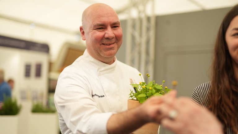 Koch Eberhard Braun hält einen Blumentopf in der Hand