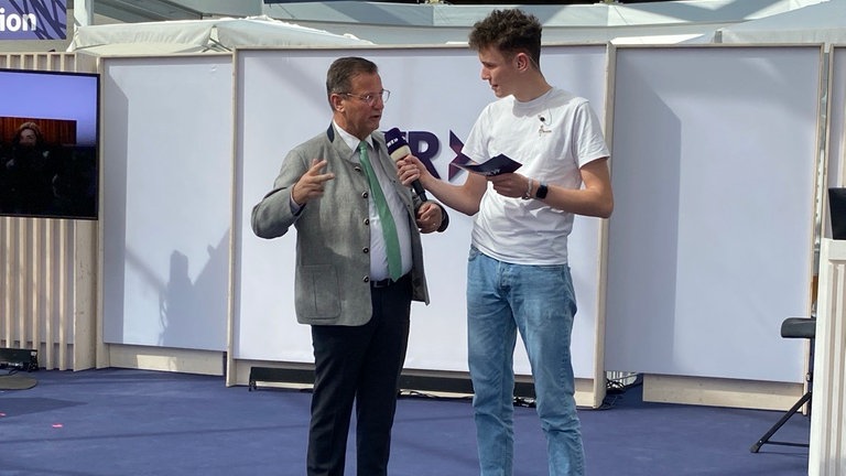 Zwei Männer stehen auf einer Bühne.